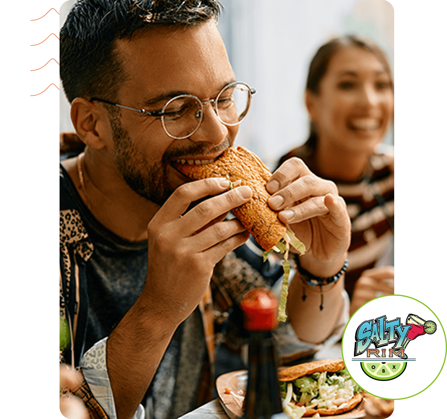Man happily eating a sandwich with friends.