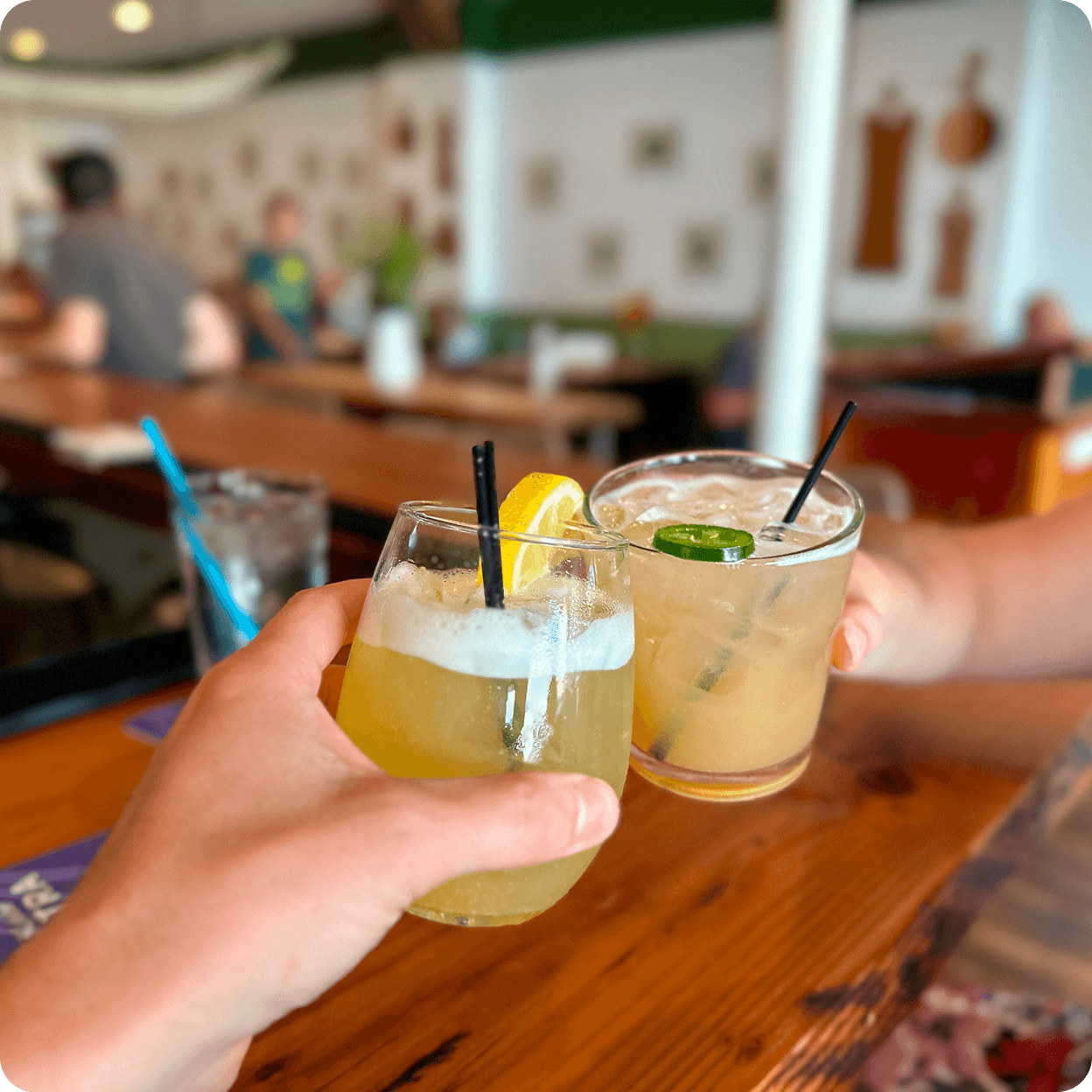Toasting with cocktails at a bar.